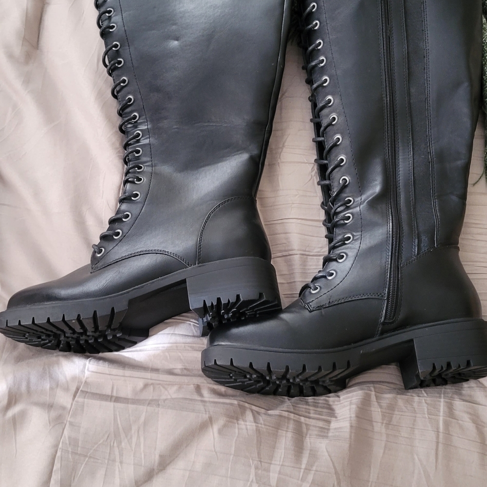 Knee high lace up combat boots.